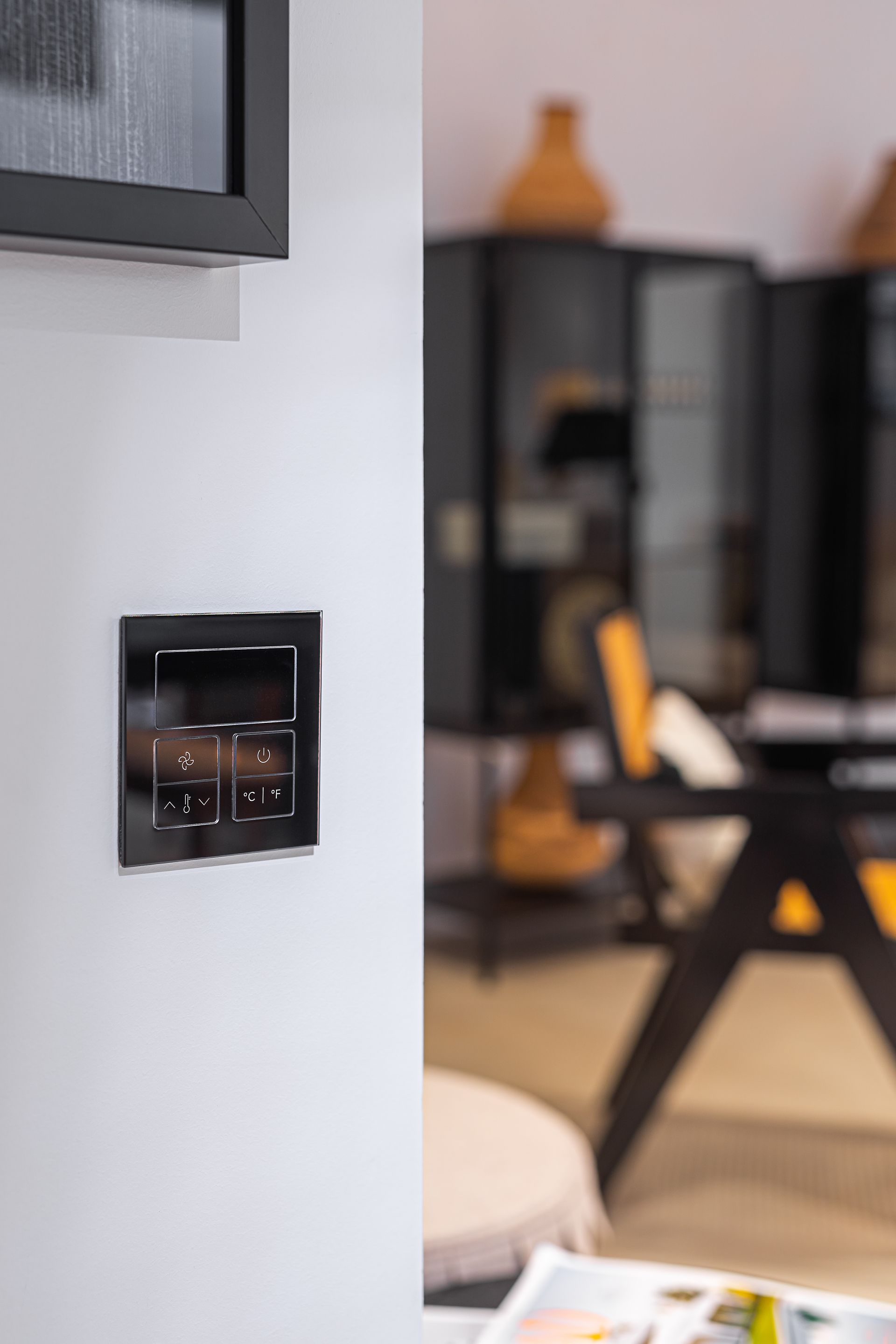 A close up of a light switch on a wall in a living room.