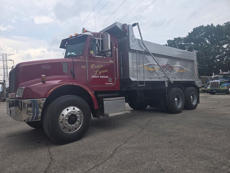 White semi-truck driving on a desert highway at sunset.