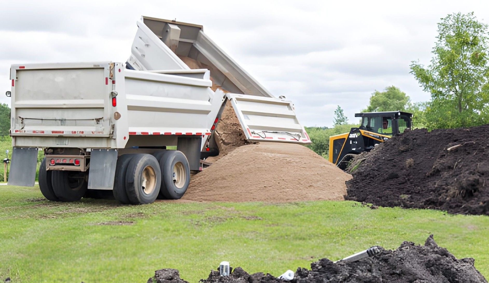 Five semi-trucks parked side-by-side; each truck is a different color: purple, silver, teal, blue, and red.