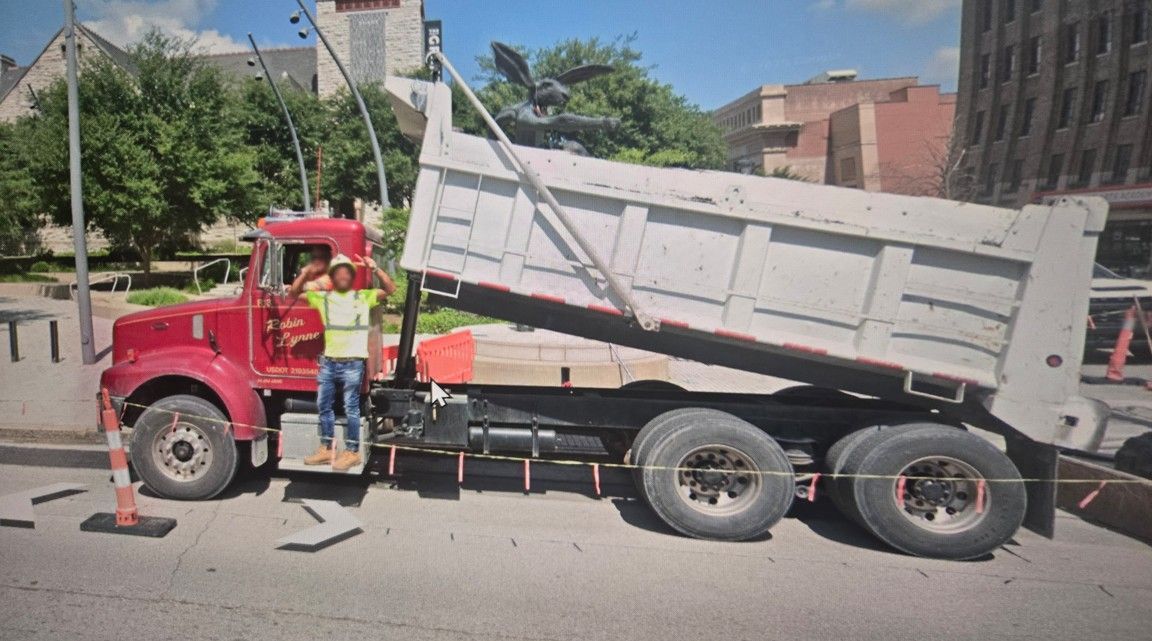 Yellow mining truck being filled with coal from an excavator in a quarry.