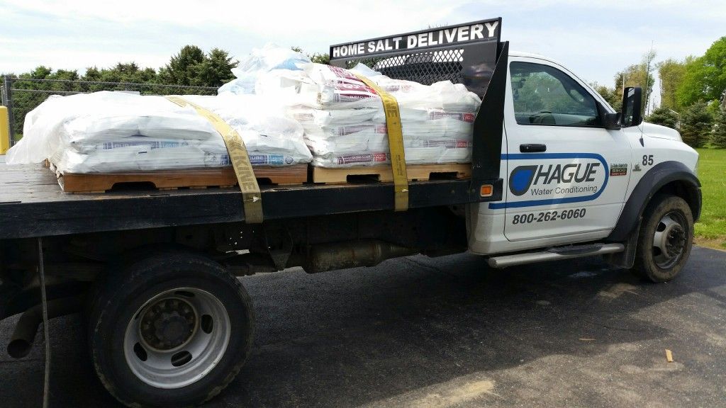 White truck with Hague Plumbing logo carries a load of bagged salt for home delivery.