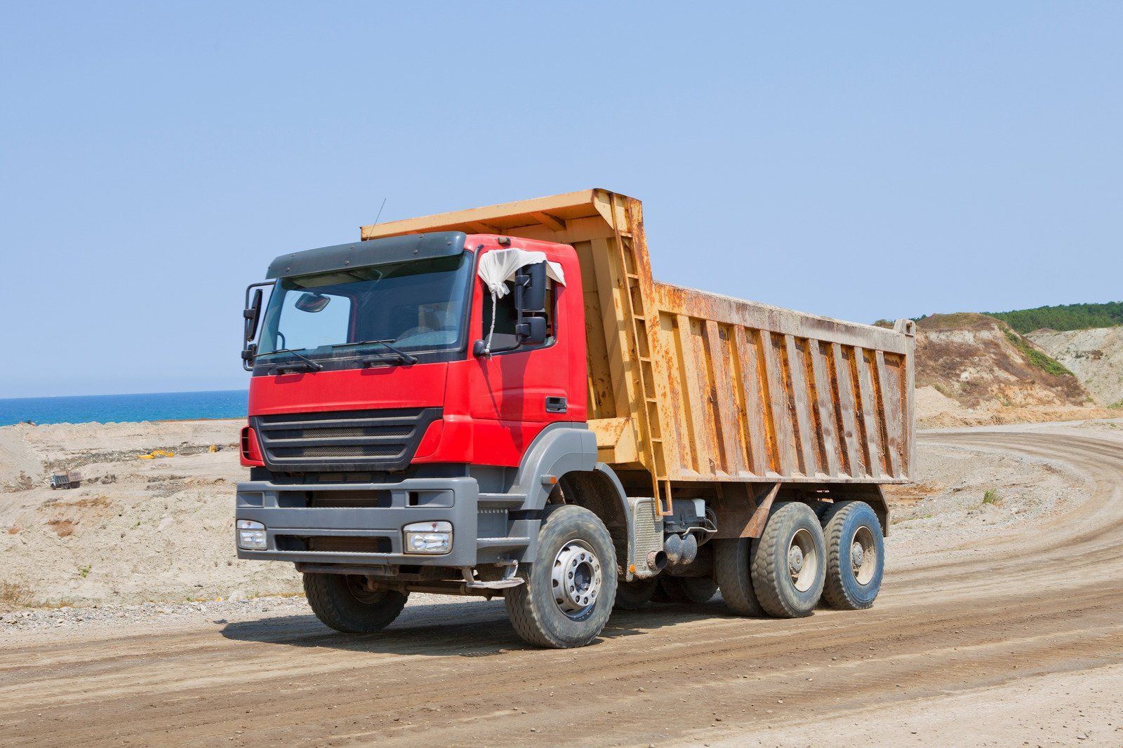 Two yellow bulldozers leveling dirt on a construction site; trees in the background.