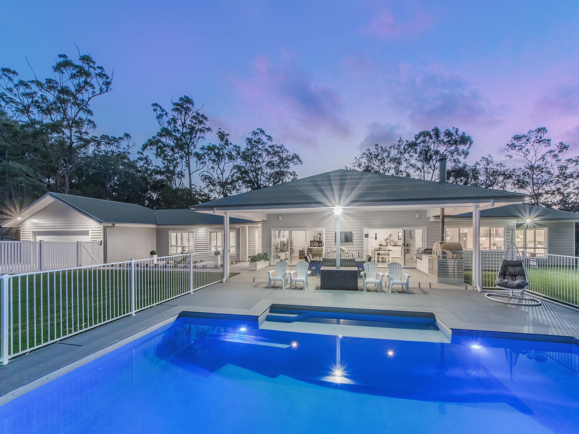 A Modern House at Twilight Featuring a Backyard Swimming Pool — Michael Duncan Constructions Pty Ltd in Ashmore, QLD