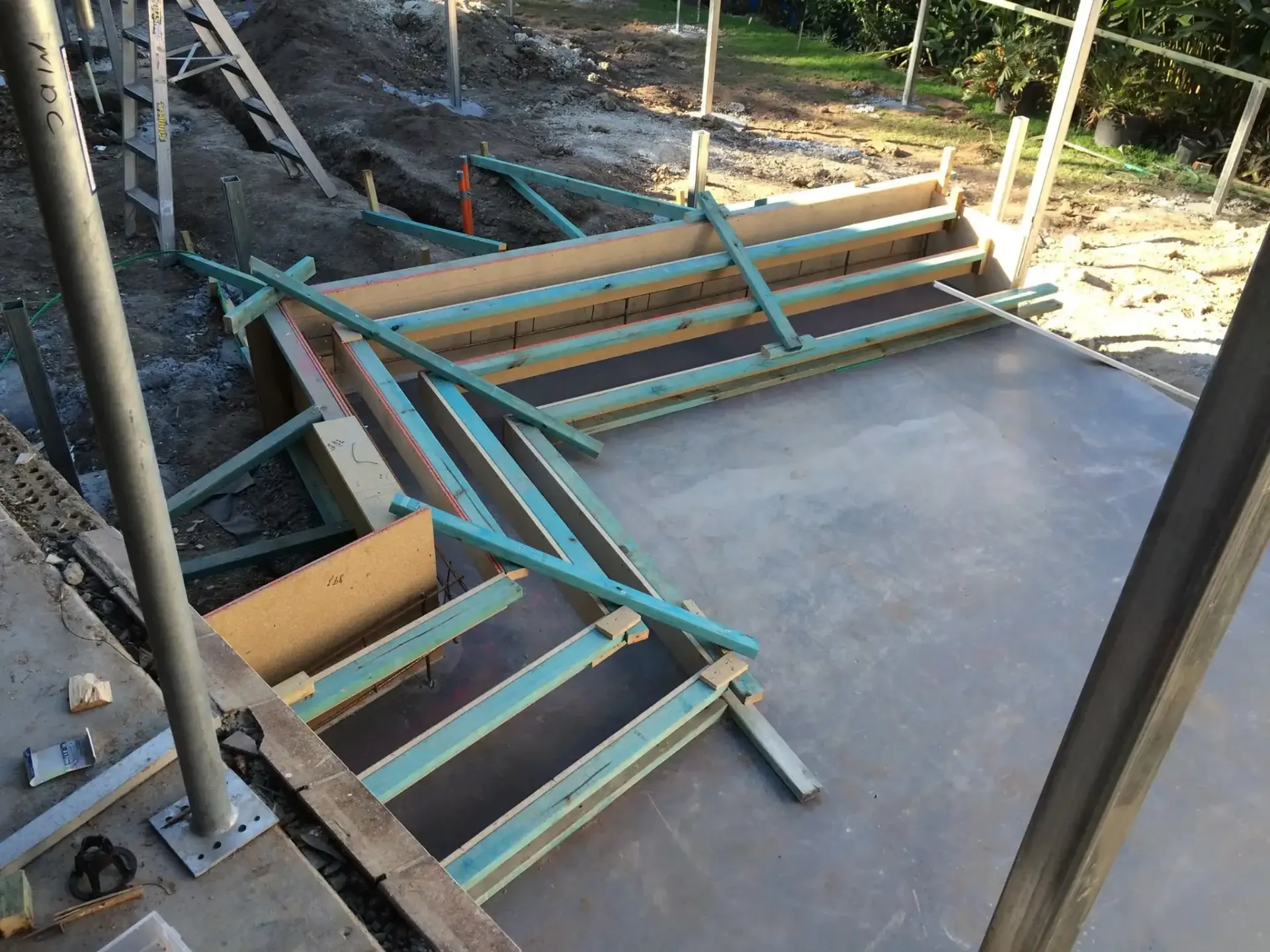 Wooden framework and steel supports for concrete forming set up on a slab at a construction site. — Michael Duncan Constructions Pty Ltd in Robina, QLD