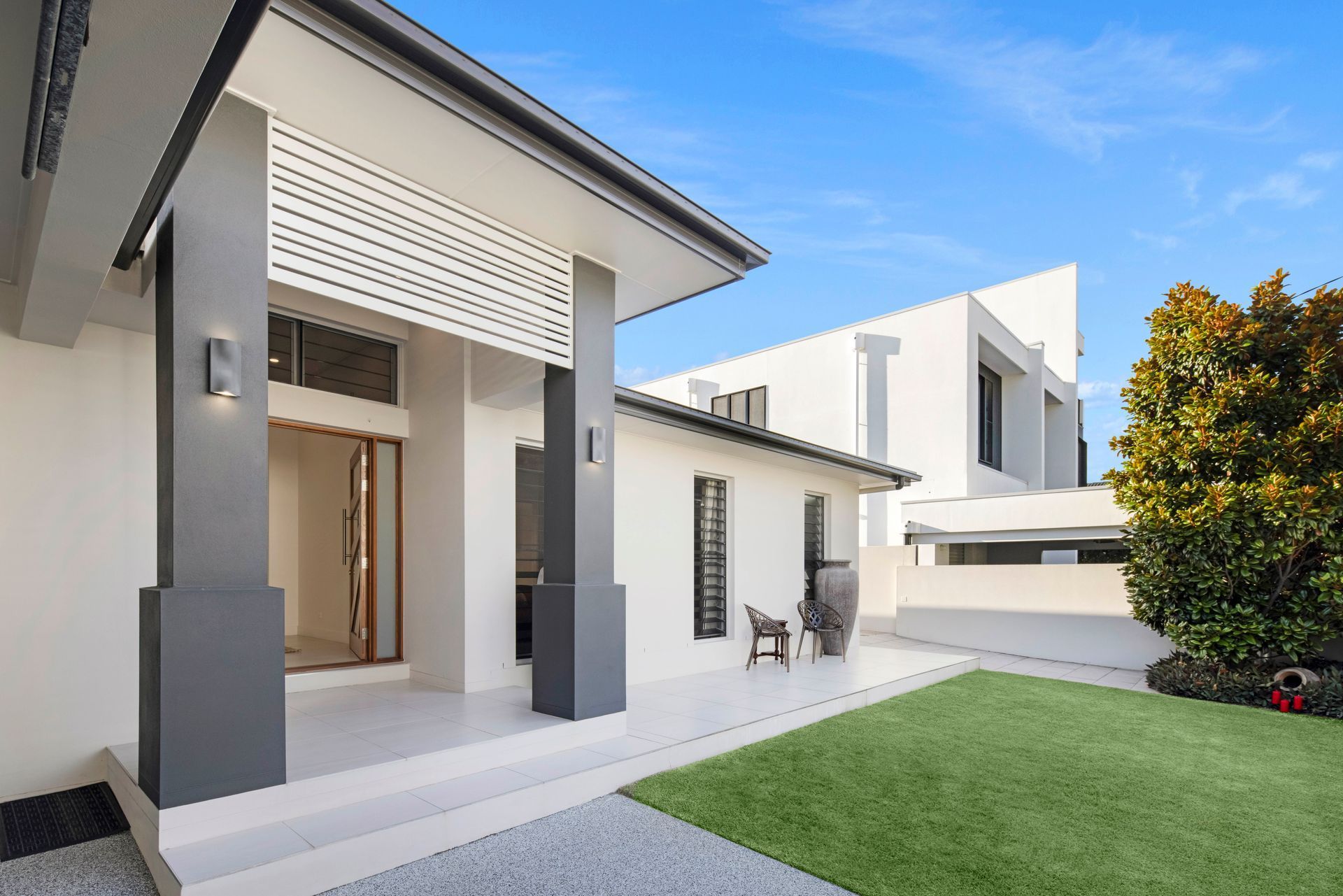 Modern White House Exterior With Gray Pillars — Michael Duncan Constructions Pty Ltd in Robina, QLD