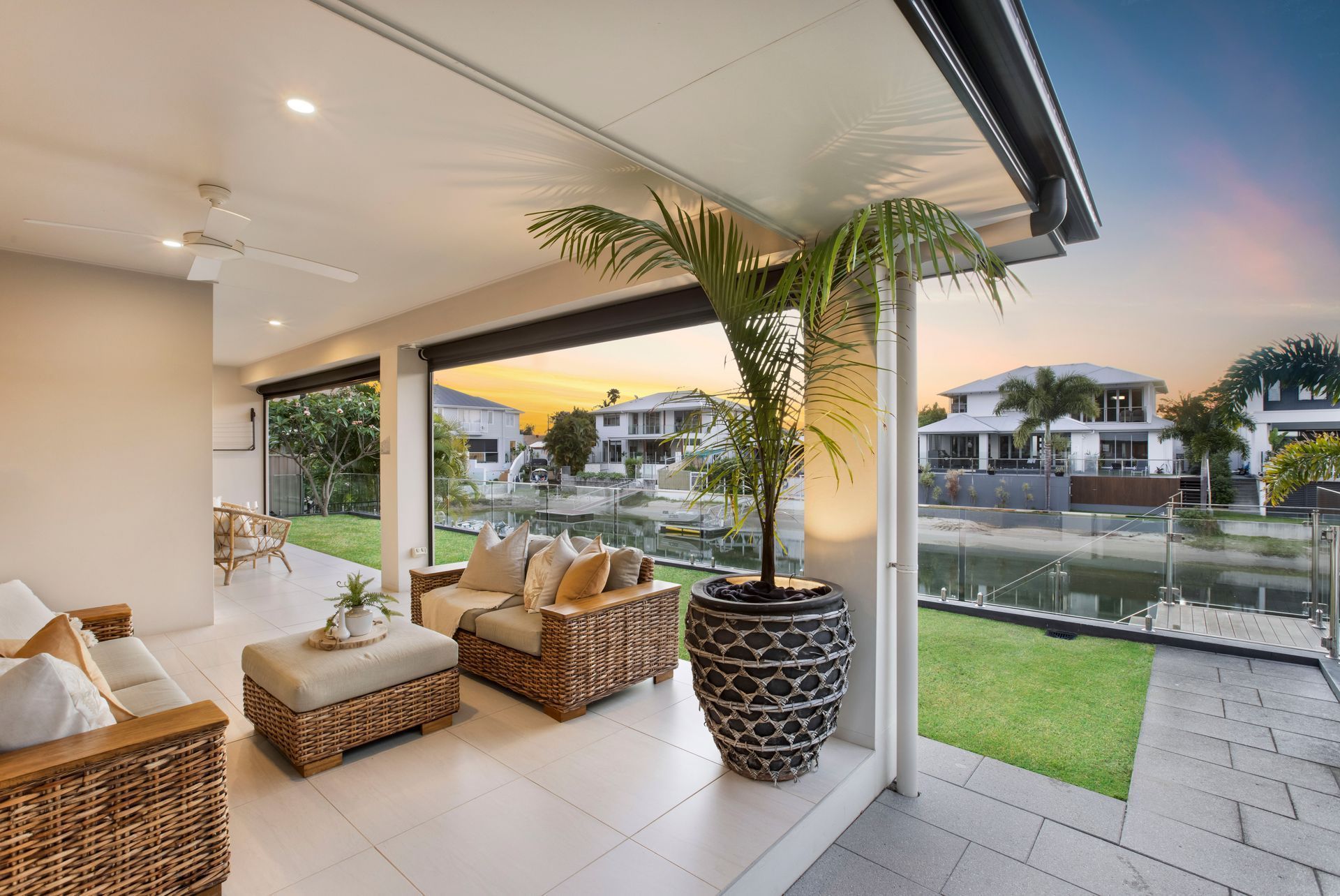 A Covered Patio With Wicker Furniture Overlooking a Canal — Michael Duncan Constructions Pty Ltd in Robina, QLD