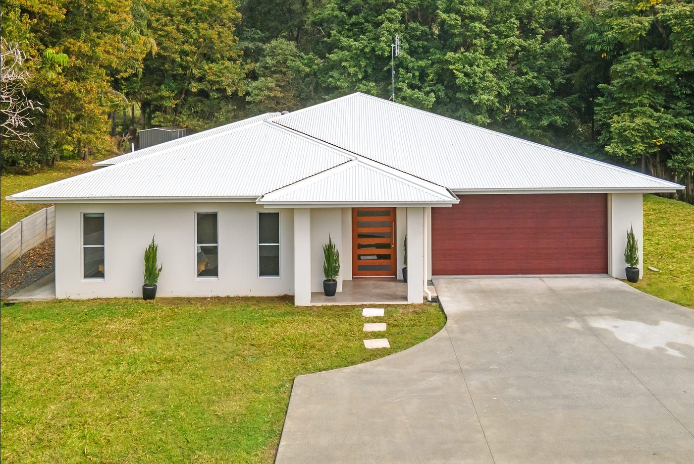 A Single-story White House With a Red Garage Door — Michael Duncan Constructions Pty Ltd in Ashmore, QLD