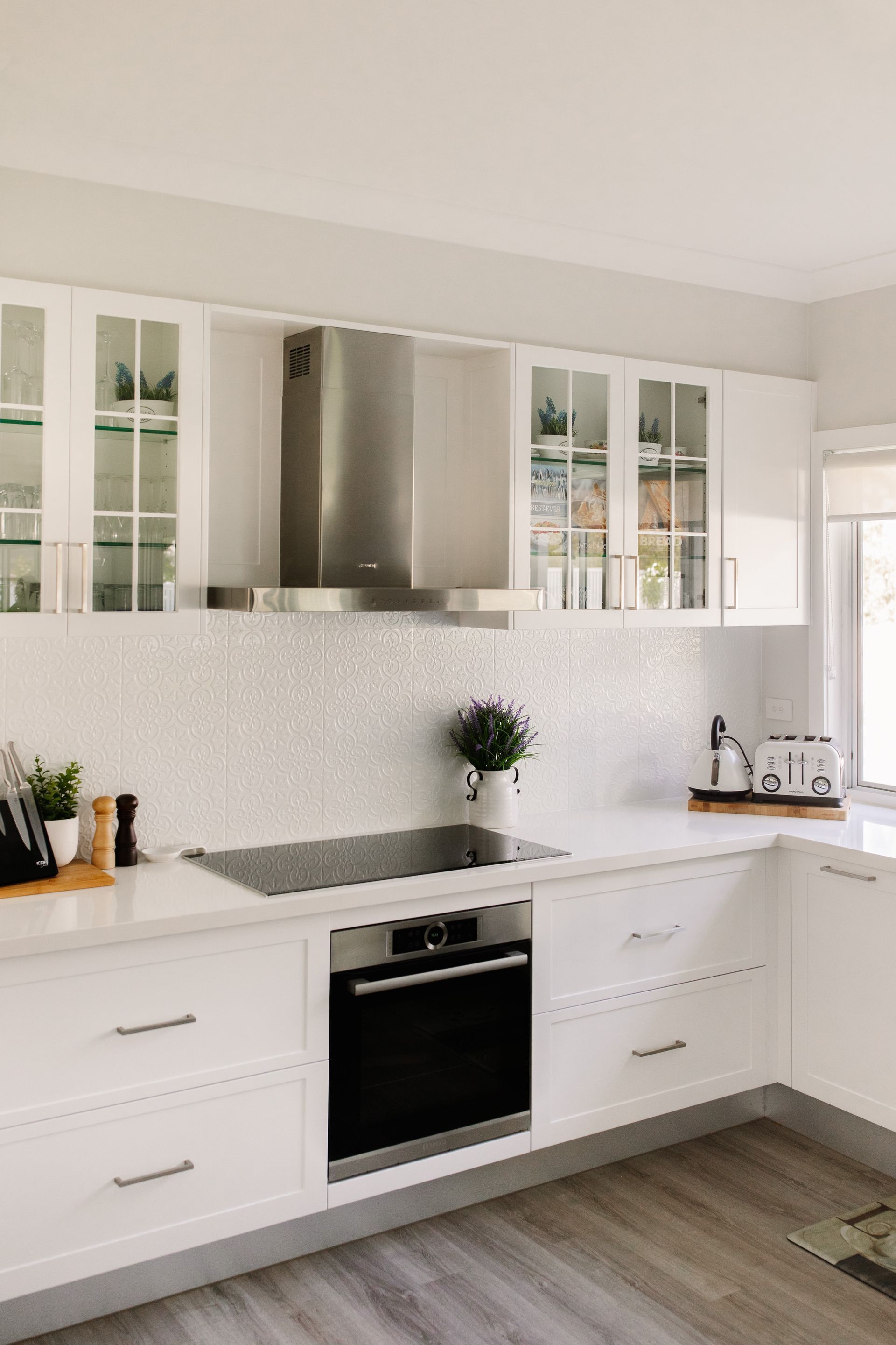 A Modern White Kitchen Featuring Glass-front Cabinets — Michael Duncan Constructions Pty Ltd in Robina, QLD