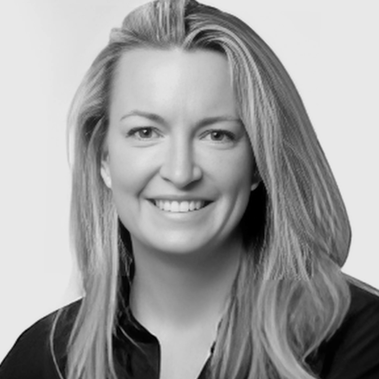 Woman with long blonde hair, smiling, in a black shirt.