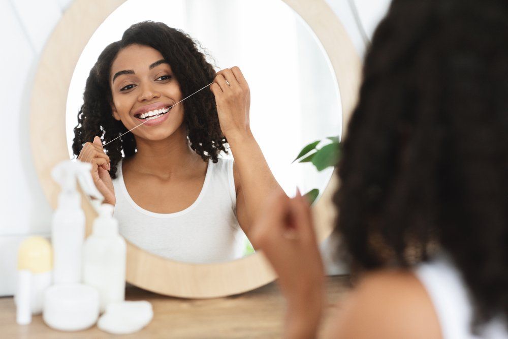 Woman Looking In The Mirror — JNT Dental — Richmond, VA