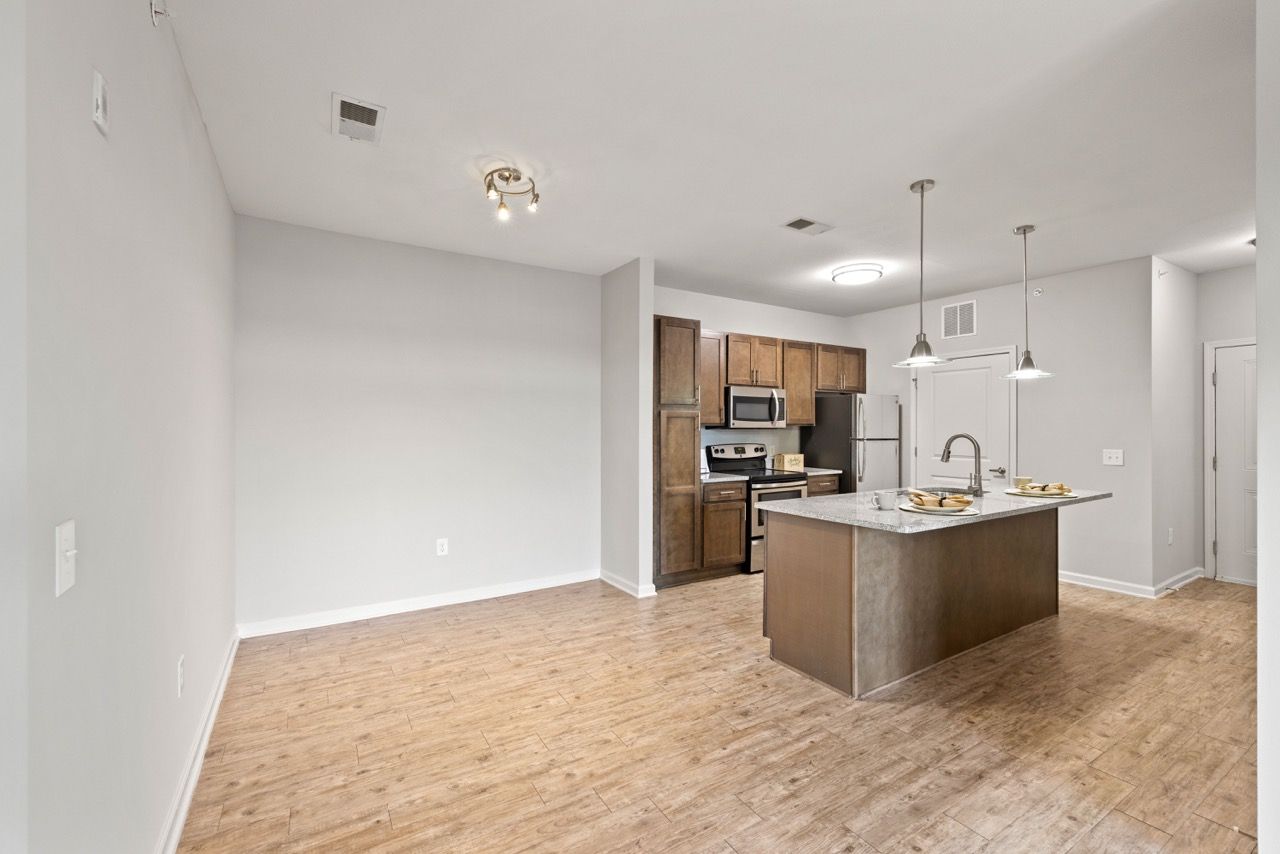 Open-concept kitchen with island, dark wood cabinets, and stainless steel appliances.