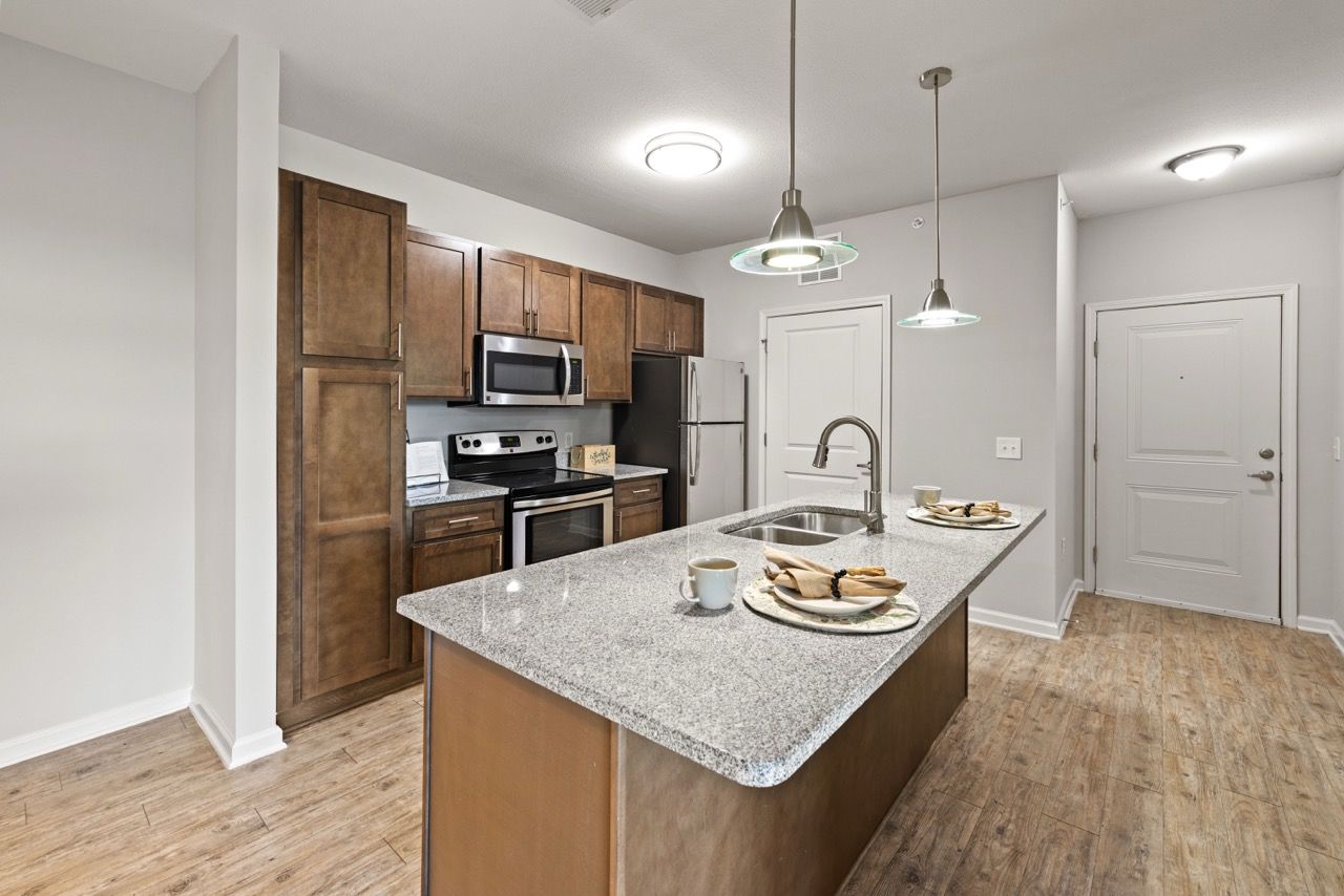 Open-concept kitchen with an island, granite countertops, and stainless steel appliances.