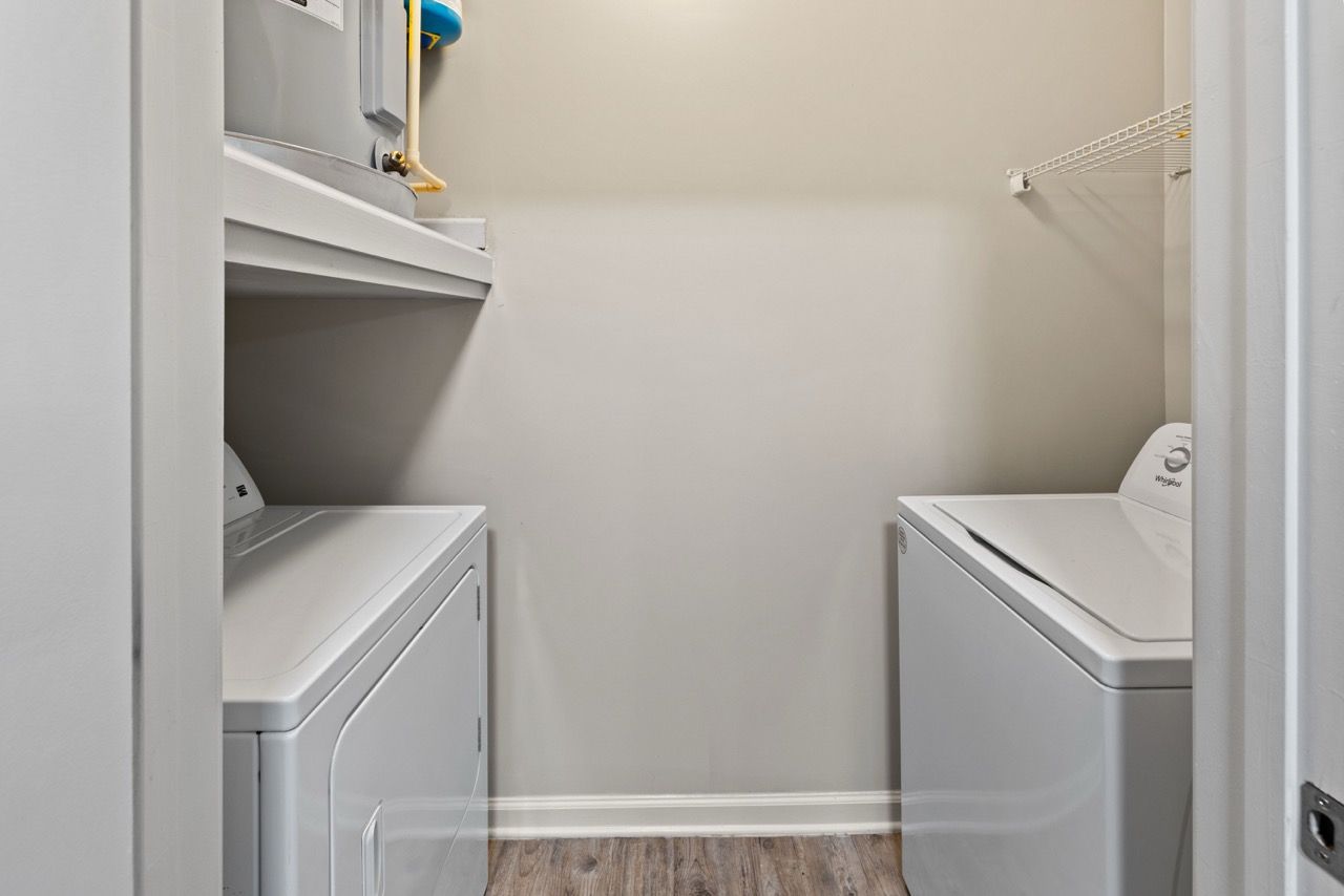 Laundry nook with front-loading washer, top-loading dryer, and a shelf.
