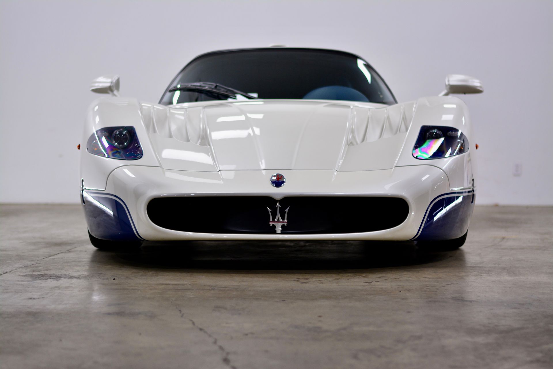 White and blue Maserati MC12 sports car, front view.