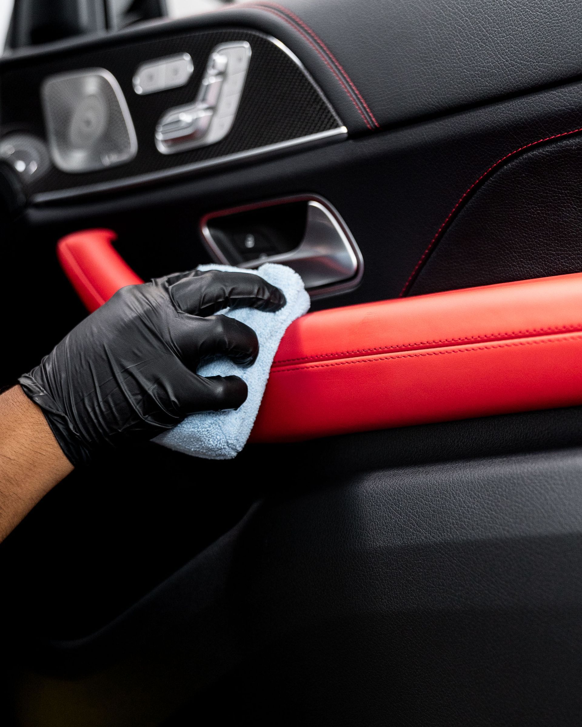 A person is cleaning the interior of a car with a cloth.