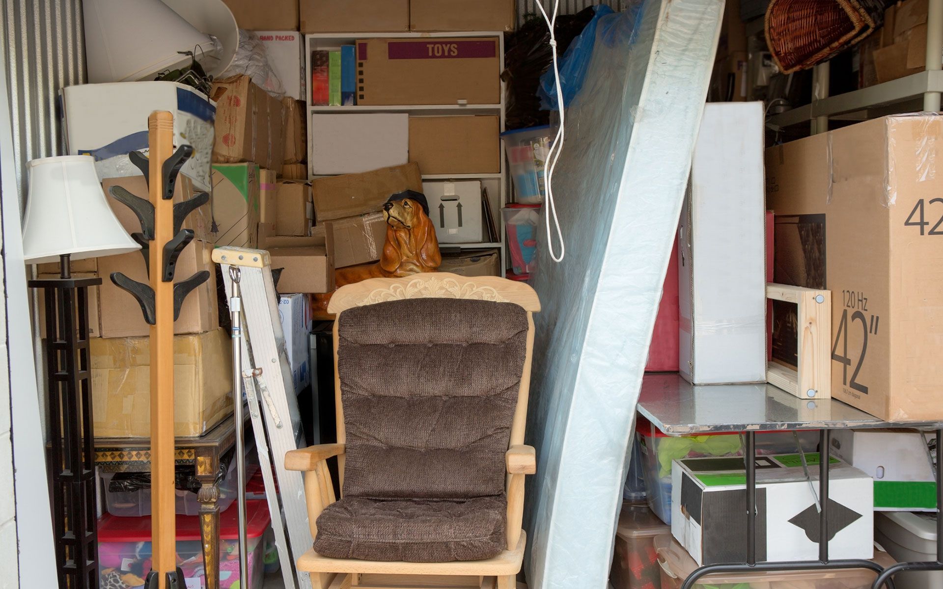 A room filled with lots of boxes and a chair.