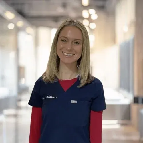 A smiling doctor in a lab coat with a stethoscope around his neck.