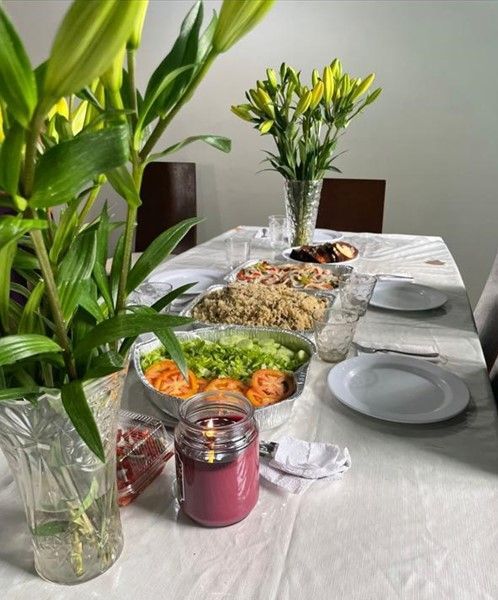 hogar gardenias Una mesa con platos de comida y flores sobre ella.