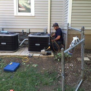 Man Repairing Condenser — Residential HVAC Contractors in Mount Vernon, OH