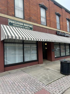 A Brick Building With A Striped Awning On The Front Of It - Ravenna, Ohio - PRCA