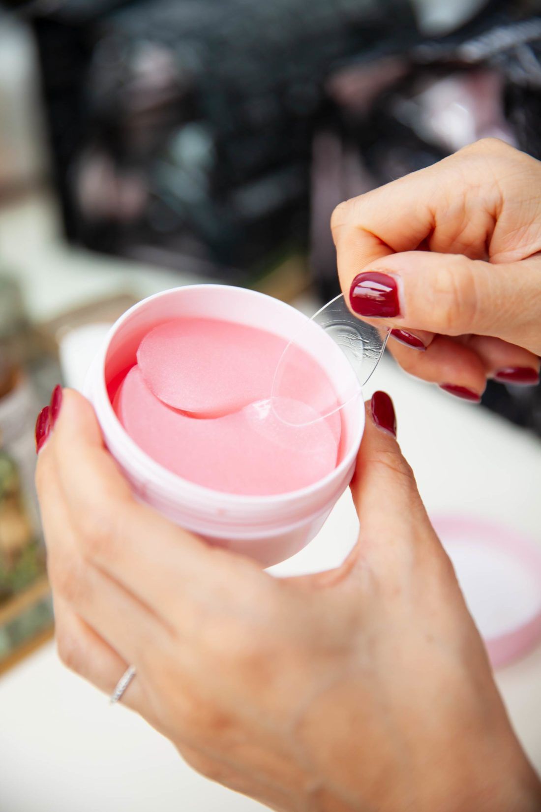 A woman is holding a jar of eye patches in her hands.