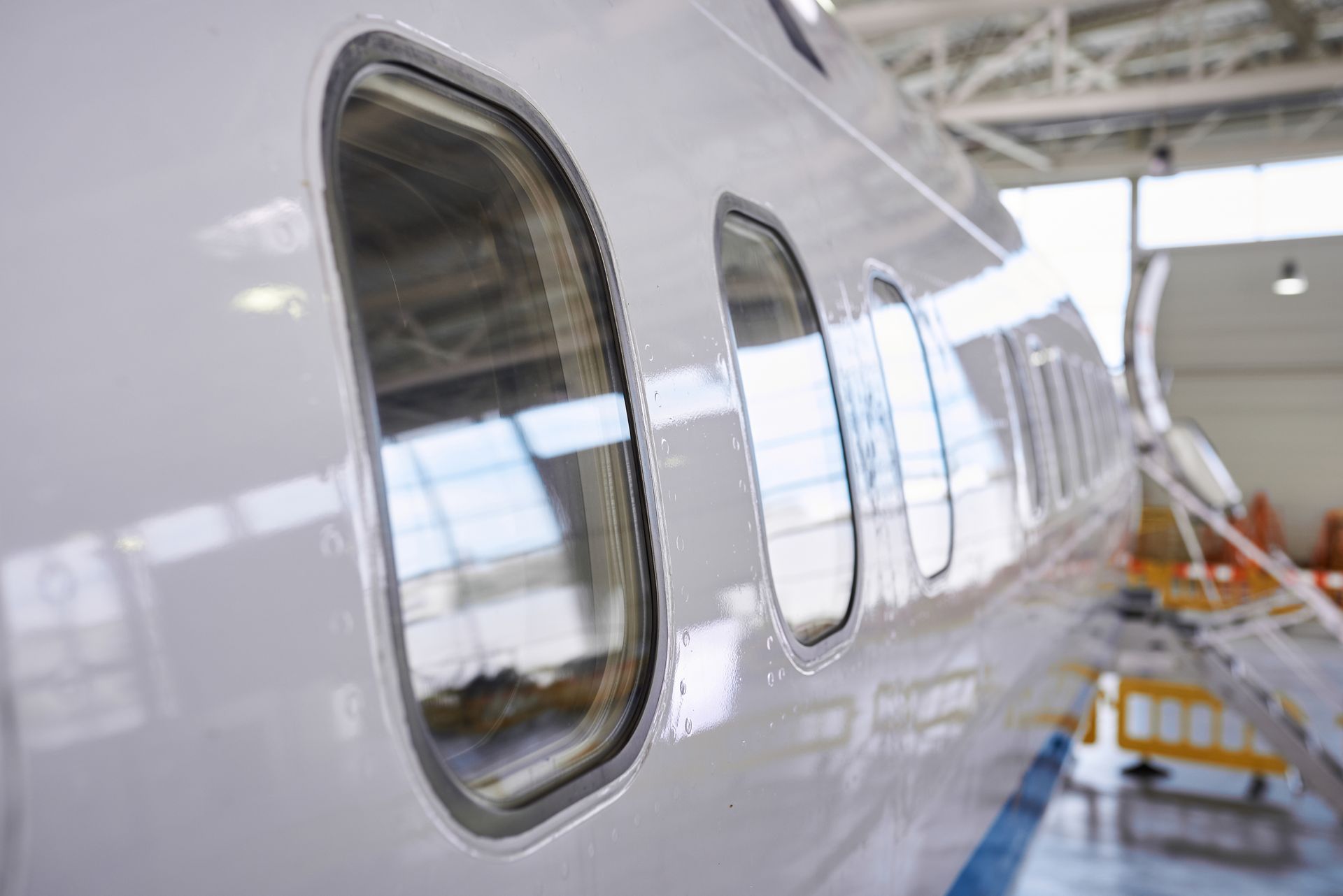A white airplane is being built in a hangar.