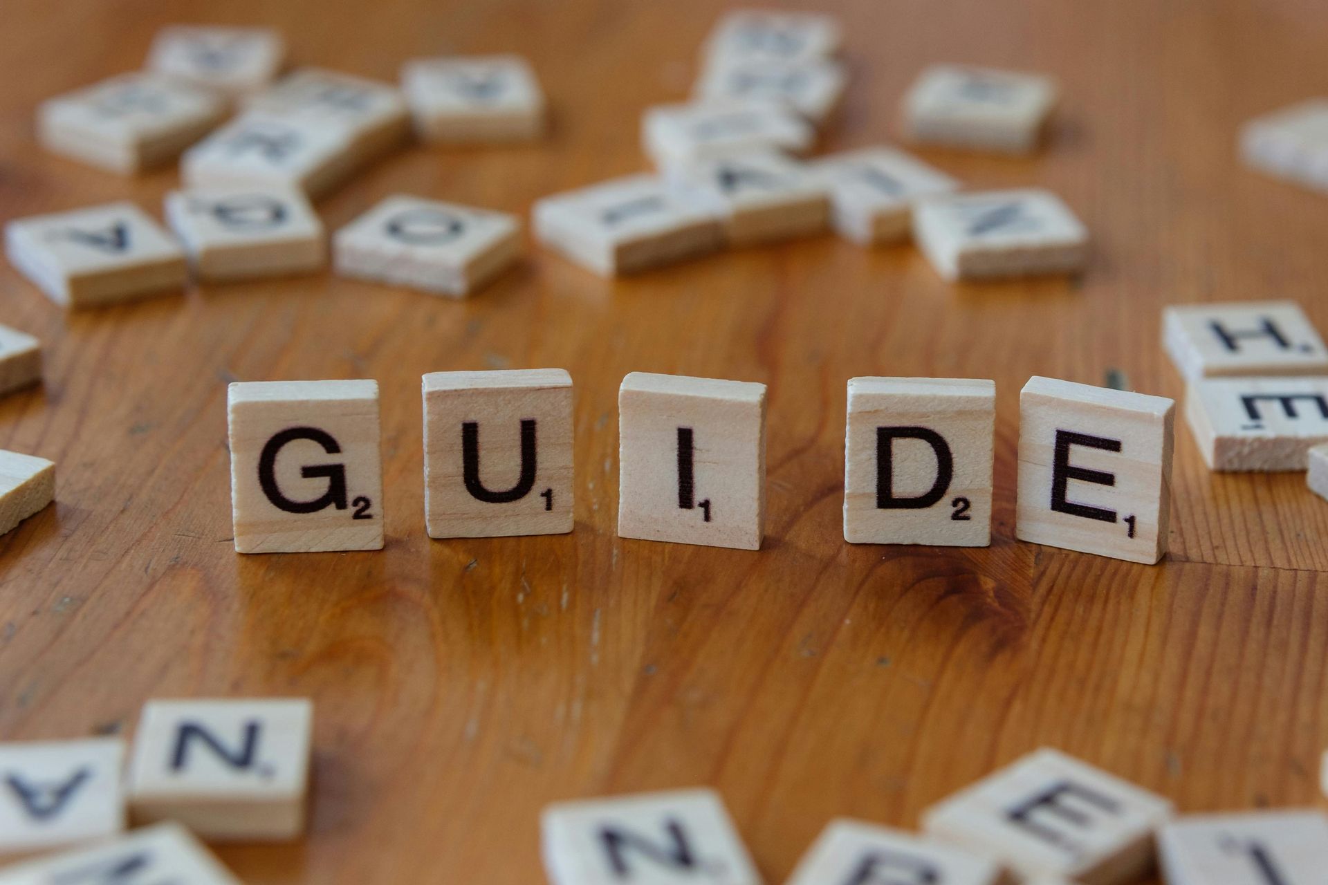 Scrabble tiles on a wooden surface spelling out the word 