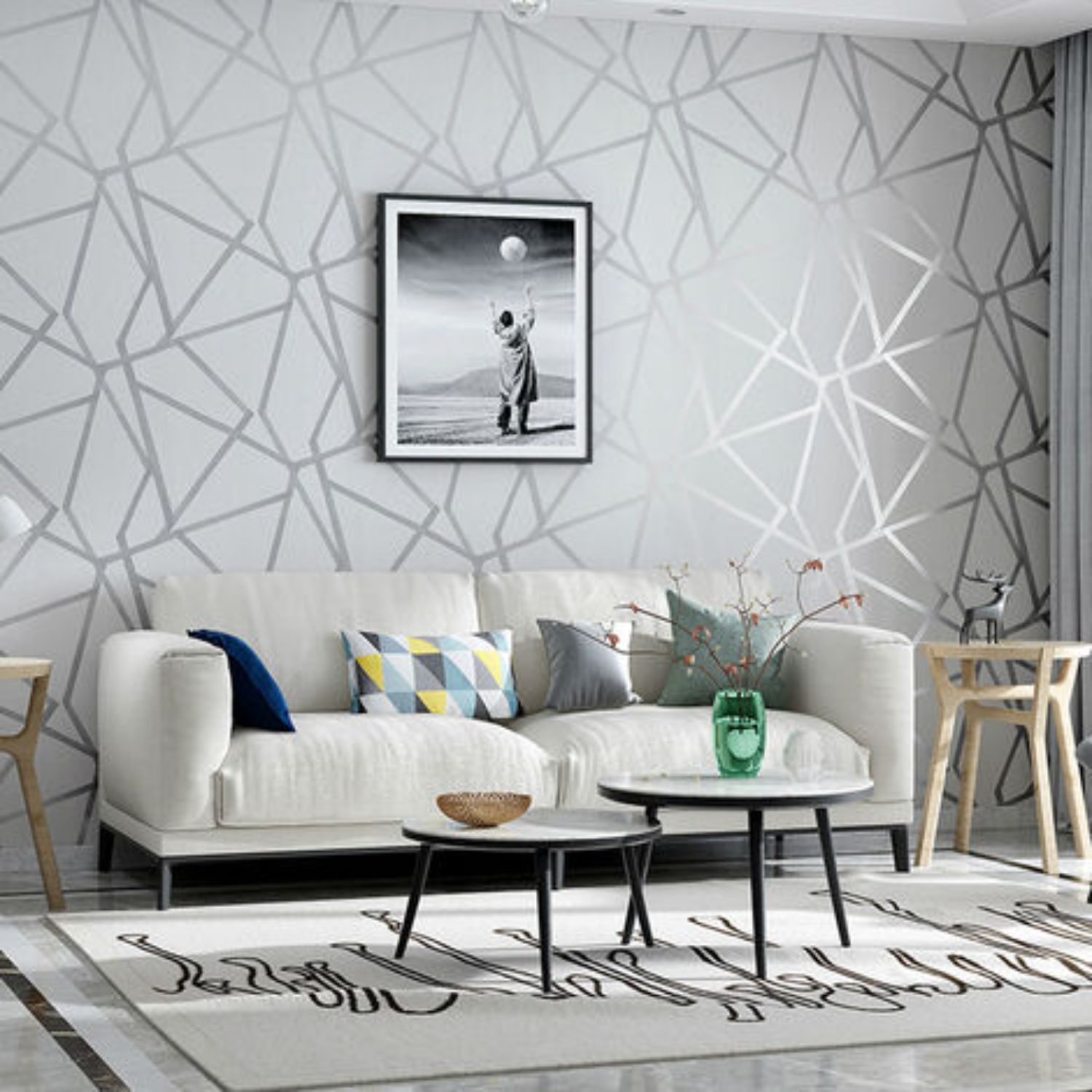 Living room with white sofa, geometric wallpaper, art print, and small tables.