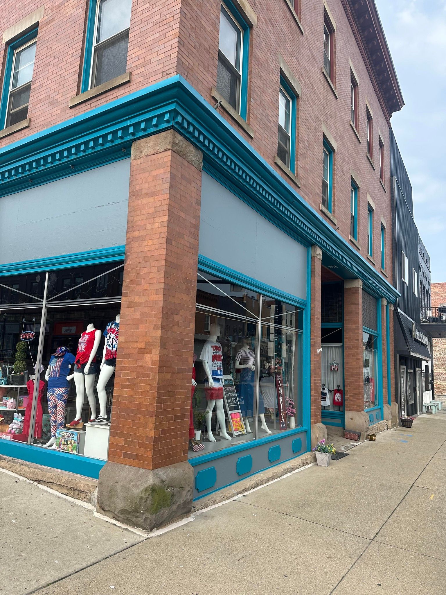 White kitchen with an island, cabinets, and appliances. Pale countertops and flooring.