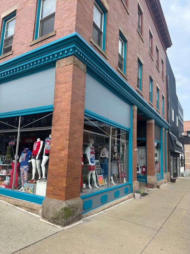 White kitchen with an island, cabinets, and appliances. Pale countertops and flooring.