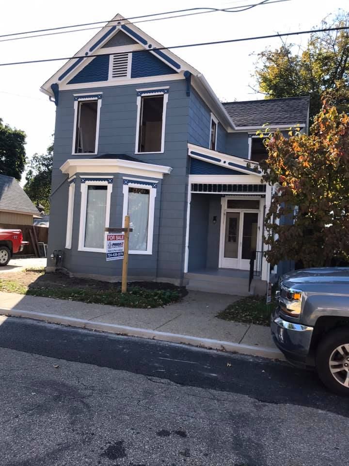 Blue two-story house with white trim. 