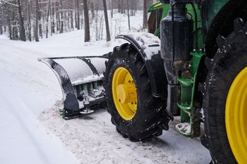 big special tractor is removing snow from forestal road