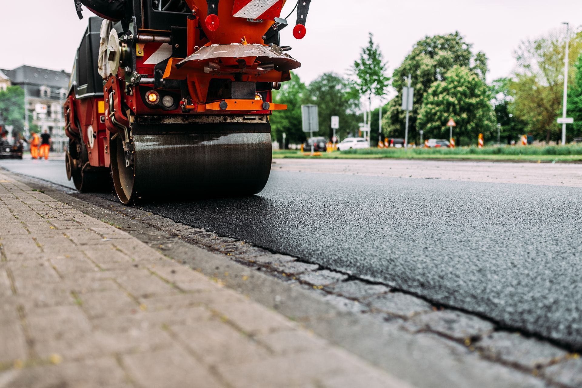 A roller is rolling asphalt on a street.