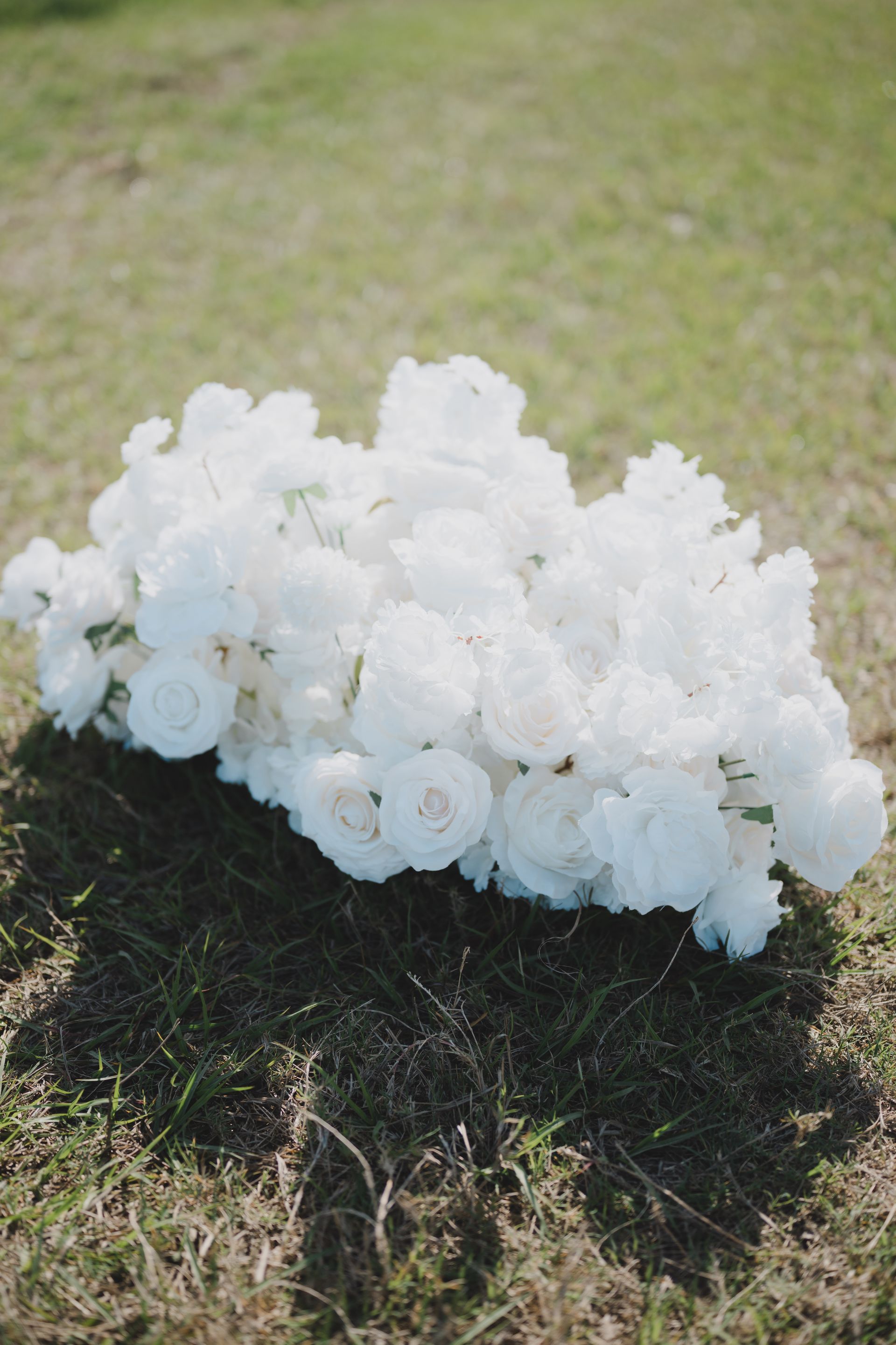 A bunch of white flowers sitting on top of a grass covered field.