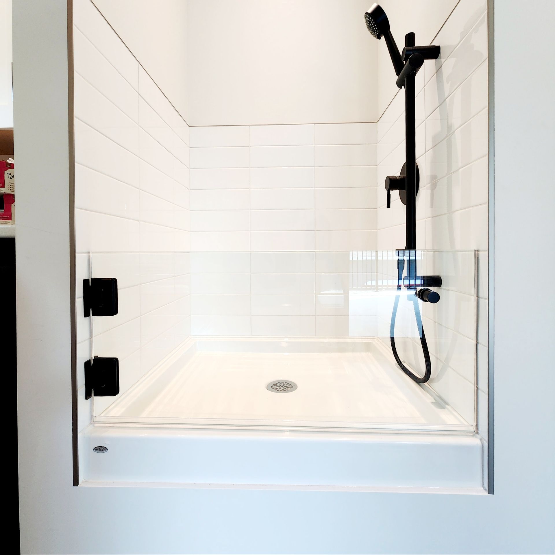 A shower stall with a glass door and a shower head