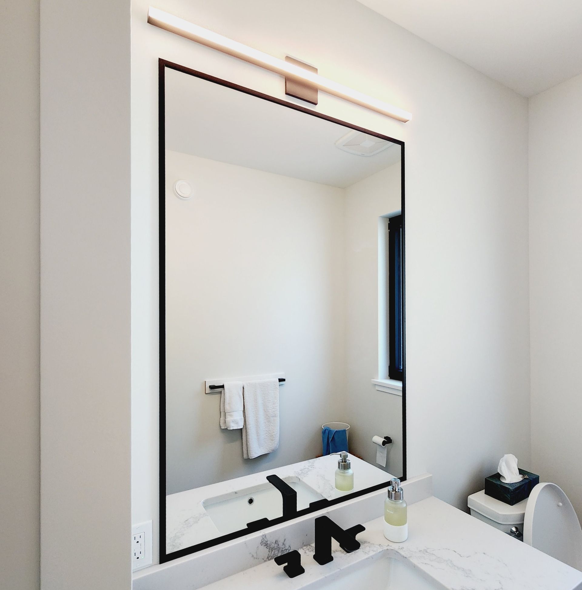 A bathroom with a large mirror and a sink.