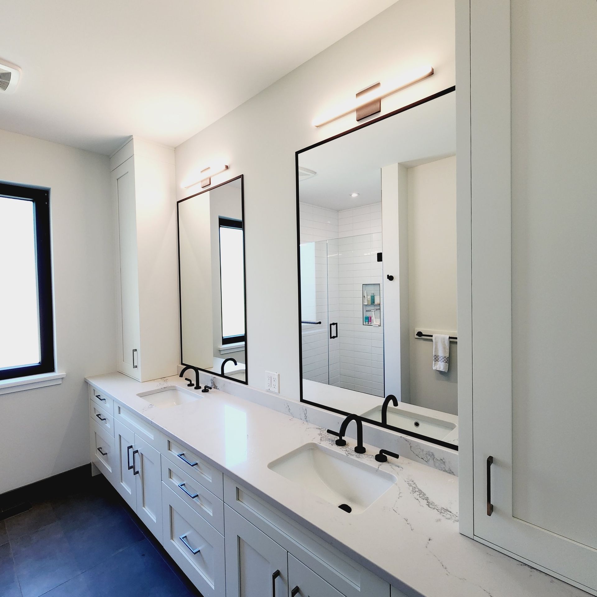 A bathroom with two sinks and two mirrors