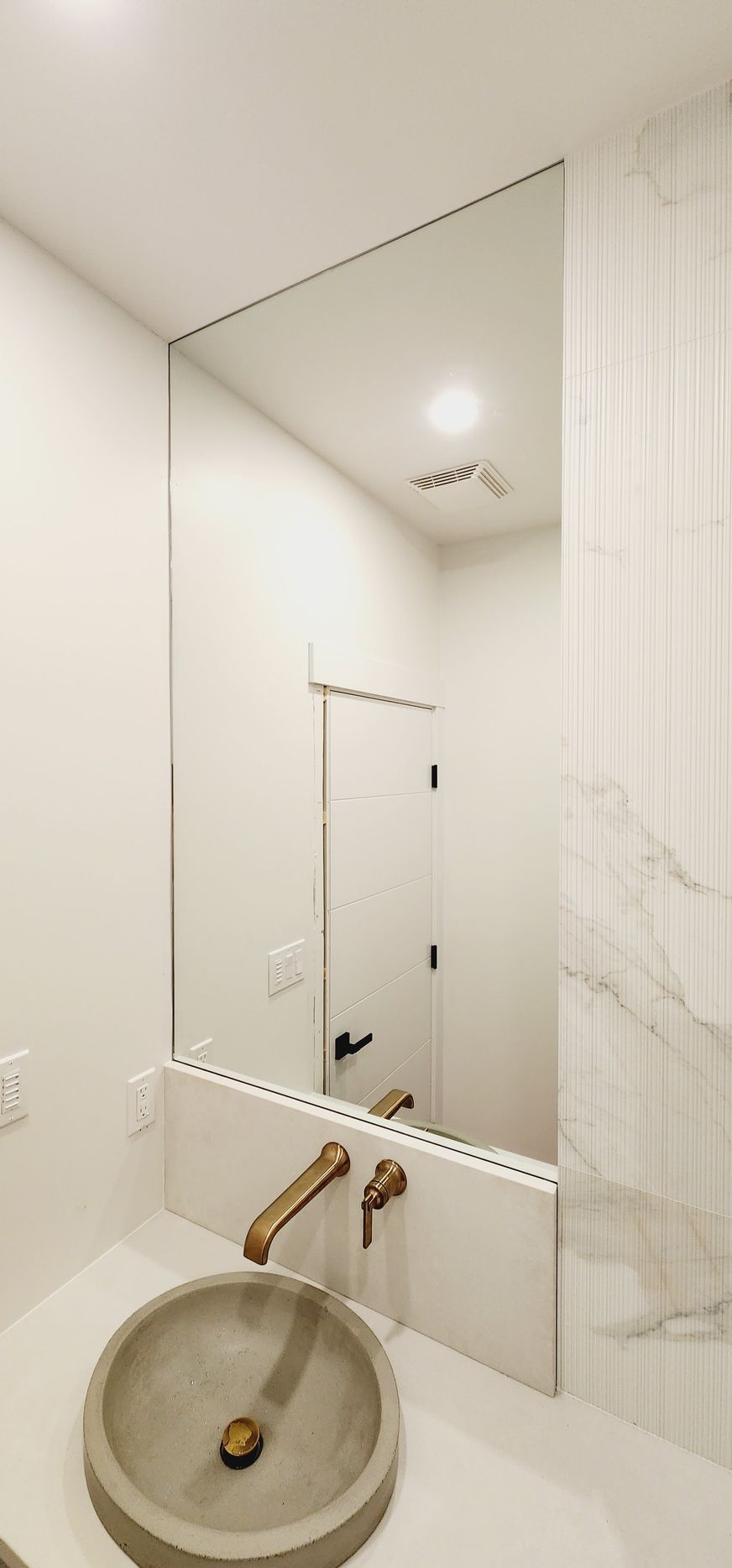 A bathroom with a sink and a large mirror.