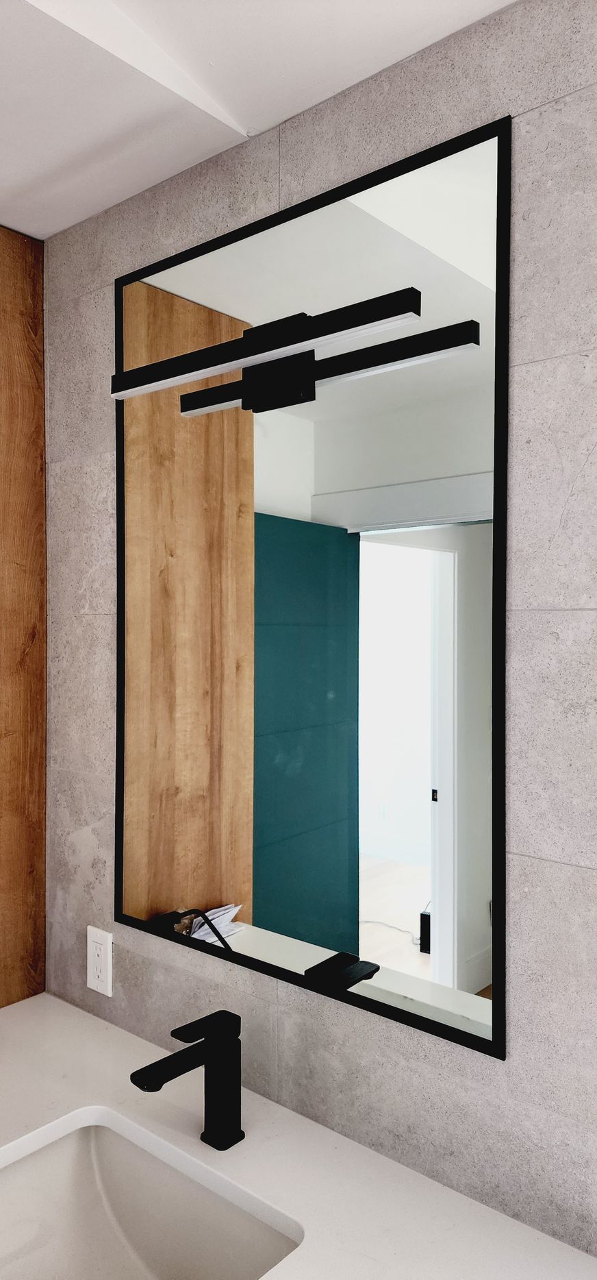 A bathroom with a large mirror and a sink.