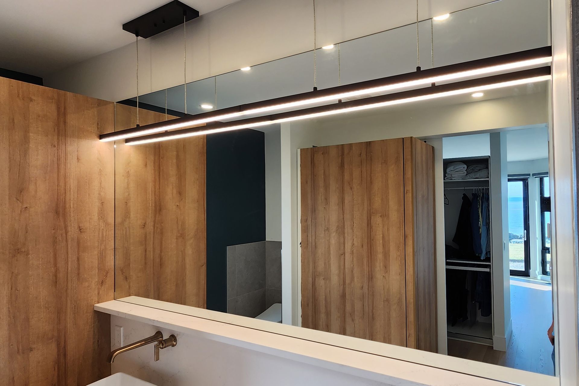A bathroom with a large mirror and a sink.