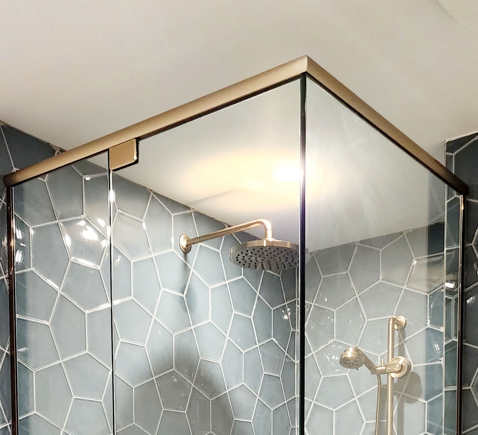 A shower stall with blue tiles and a shower head