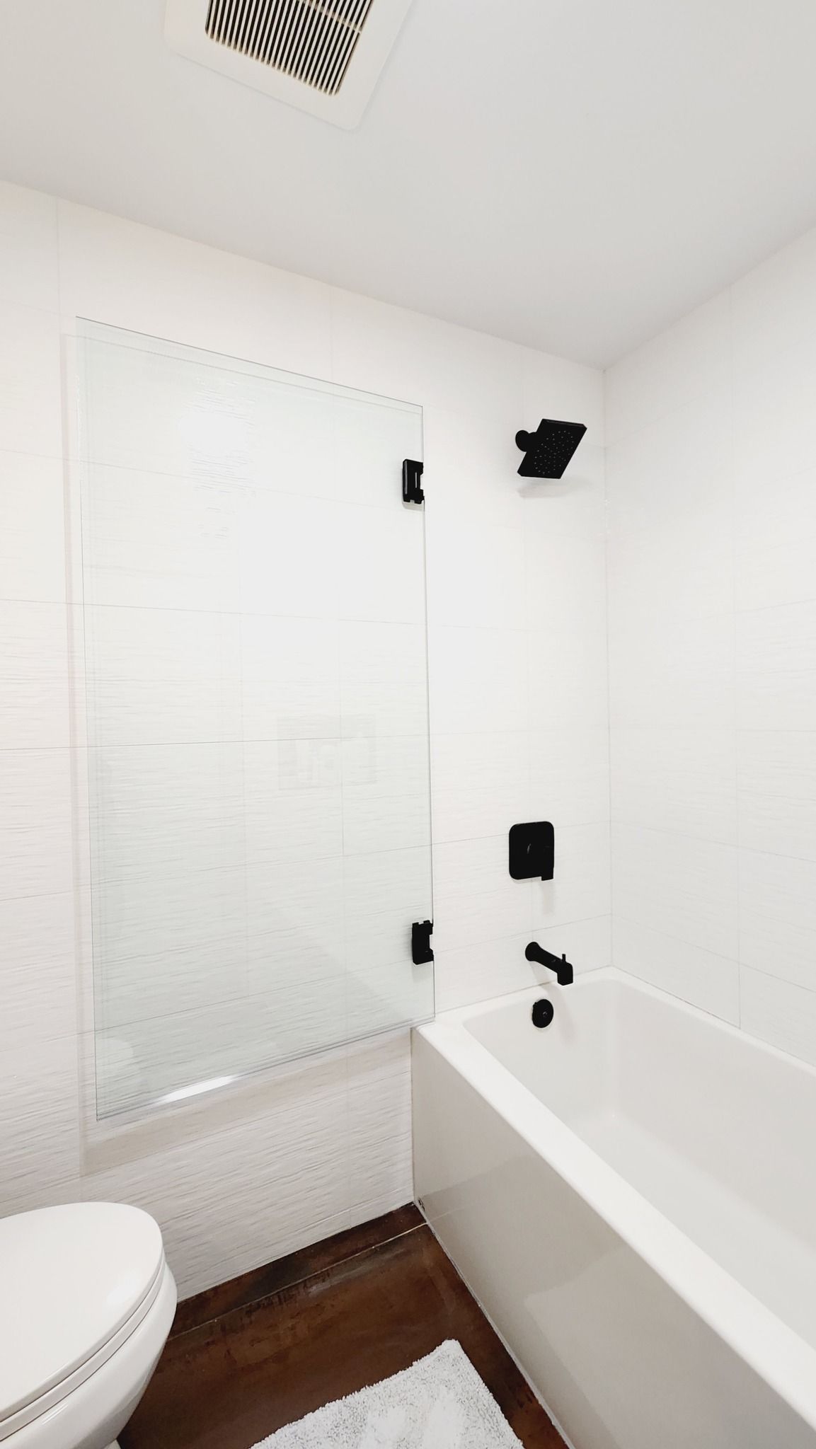 A bathroom with a tub , toilet and shower.