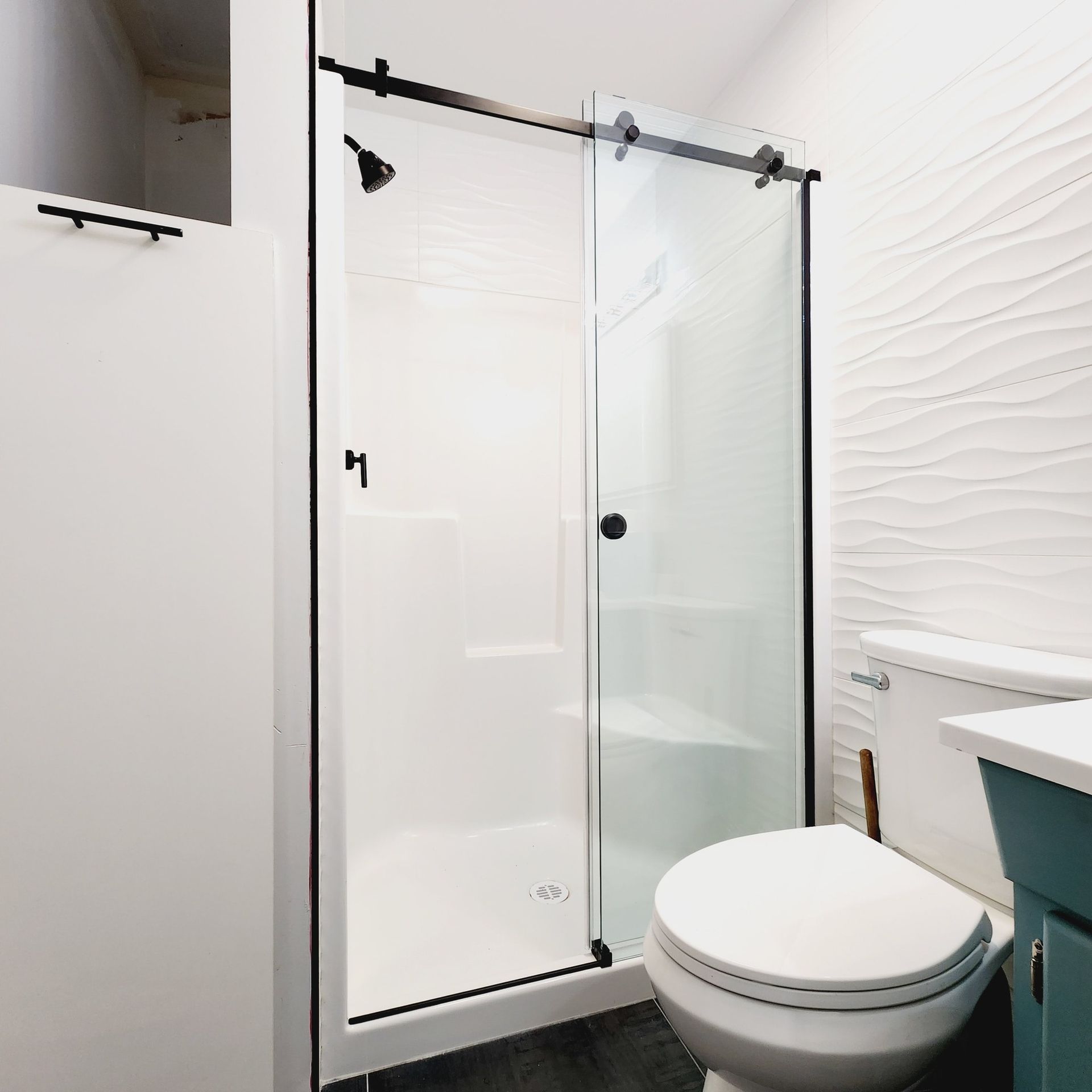 A bathroom with a toilet , sink , shower and sliding glass door.