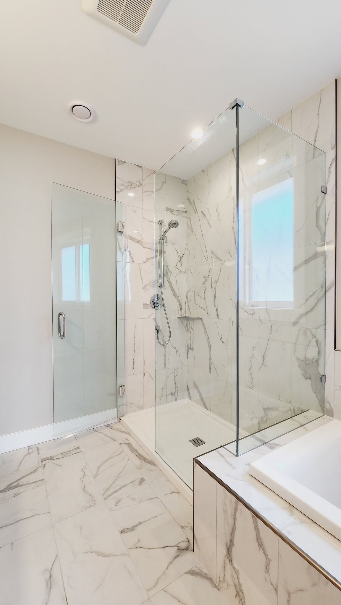 A bathroom with a walk in shower and a sink.