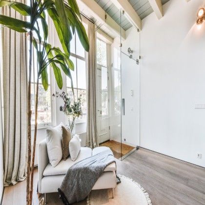 A living room with a chaise lounge and a walk in shower.