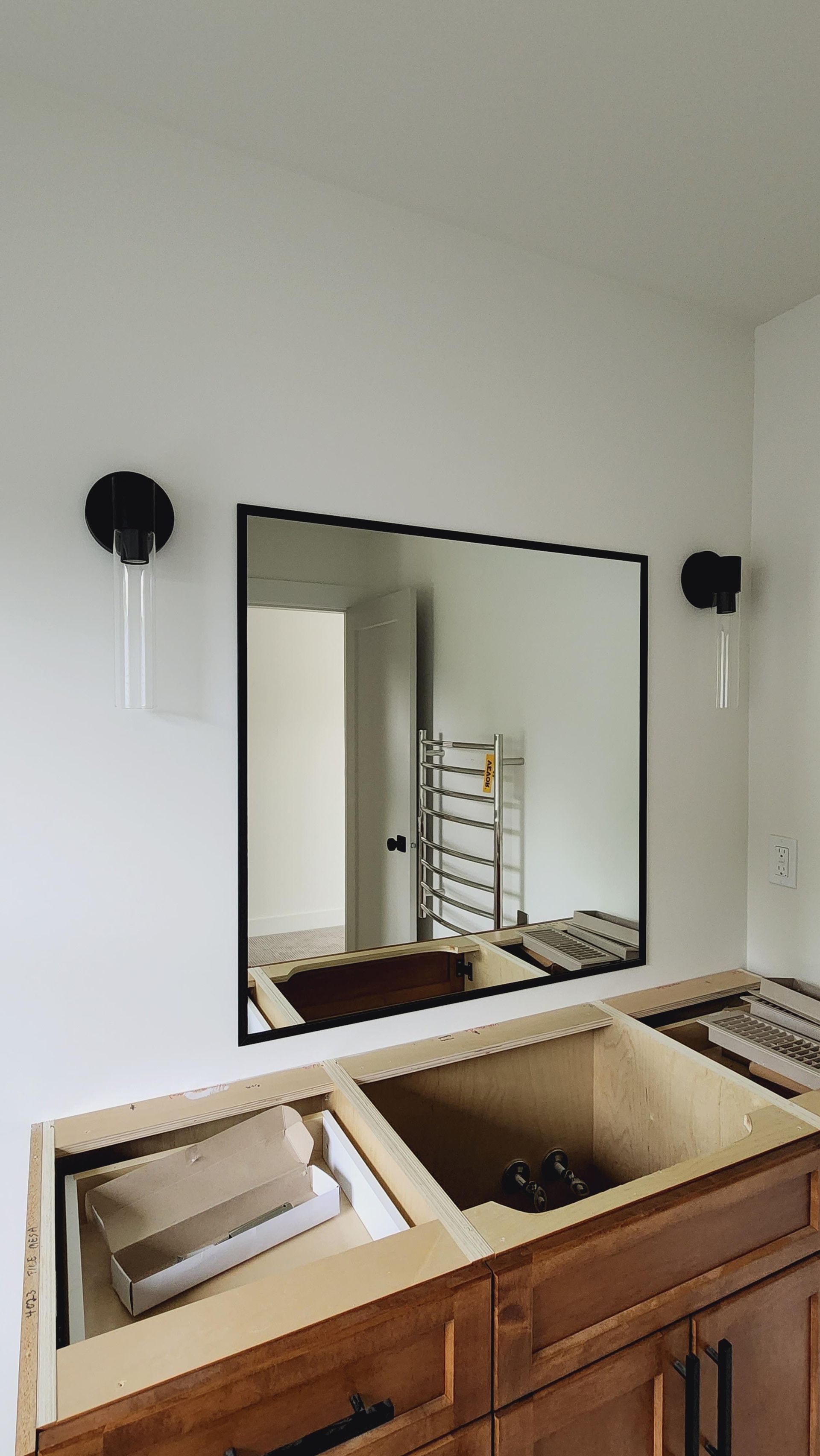 A bathroom vanity with a large mirror above it.