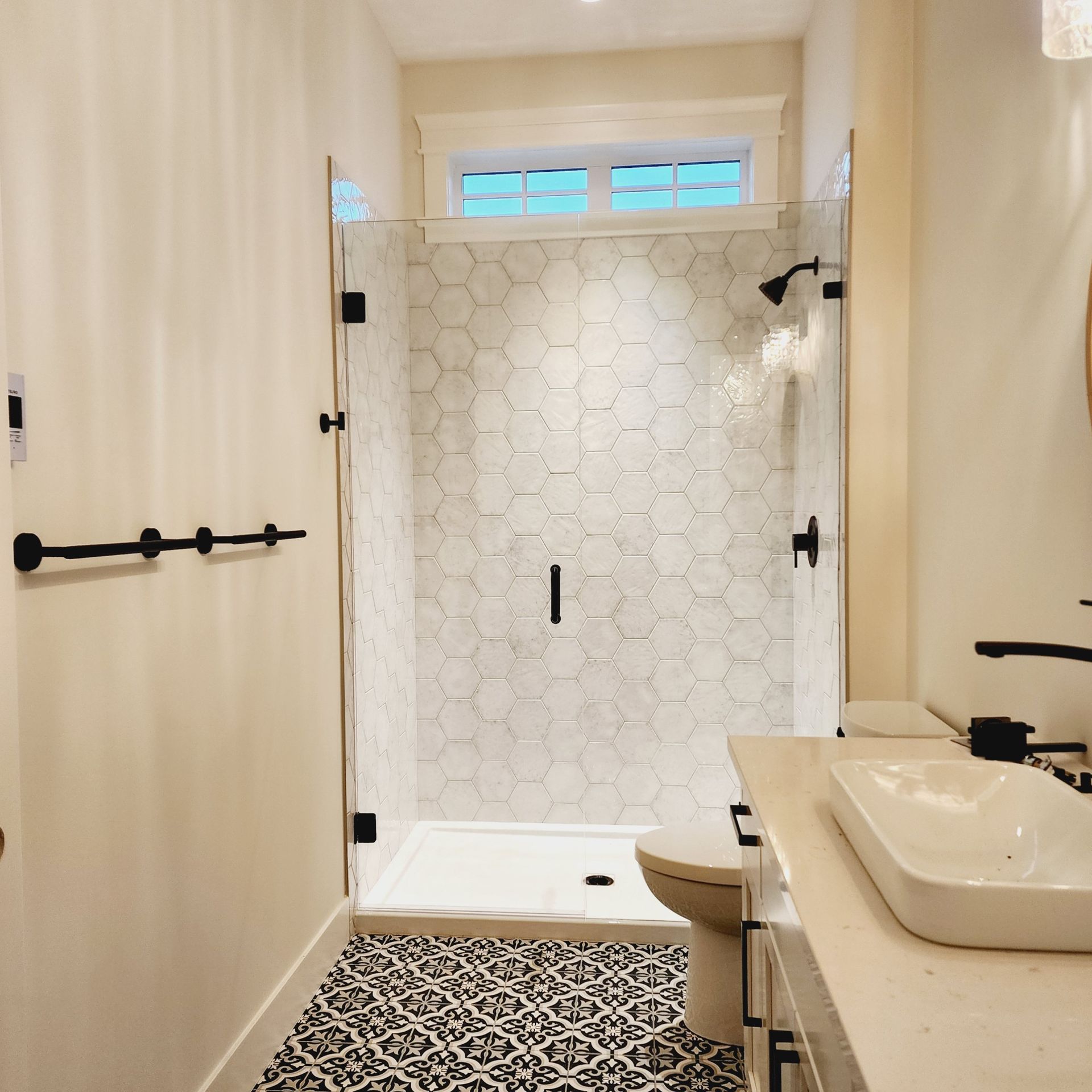 A bathroom with a walk in shower and a sink