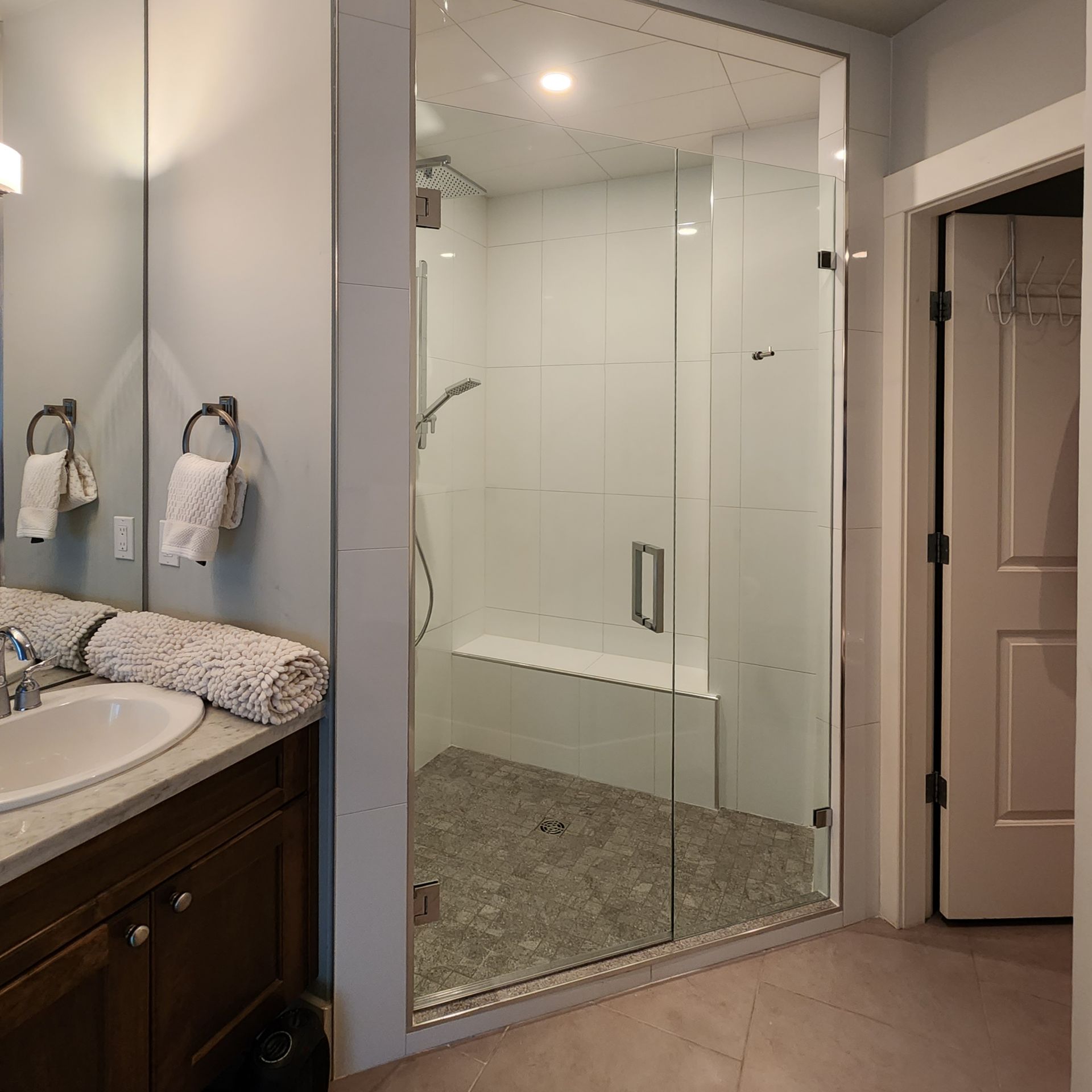 A bathroom with a walk in shower and a sink
