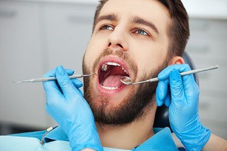 Cosmetic Dentistry — Man Getting His Teeth Checked in North Canton, OH