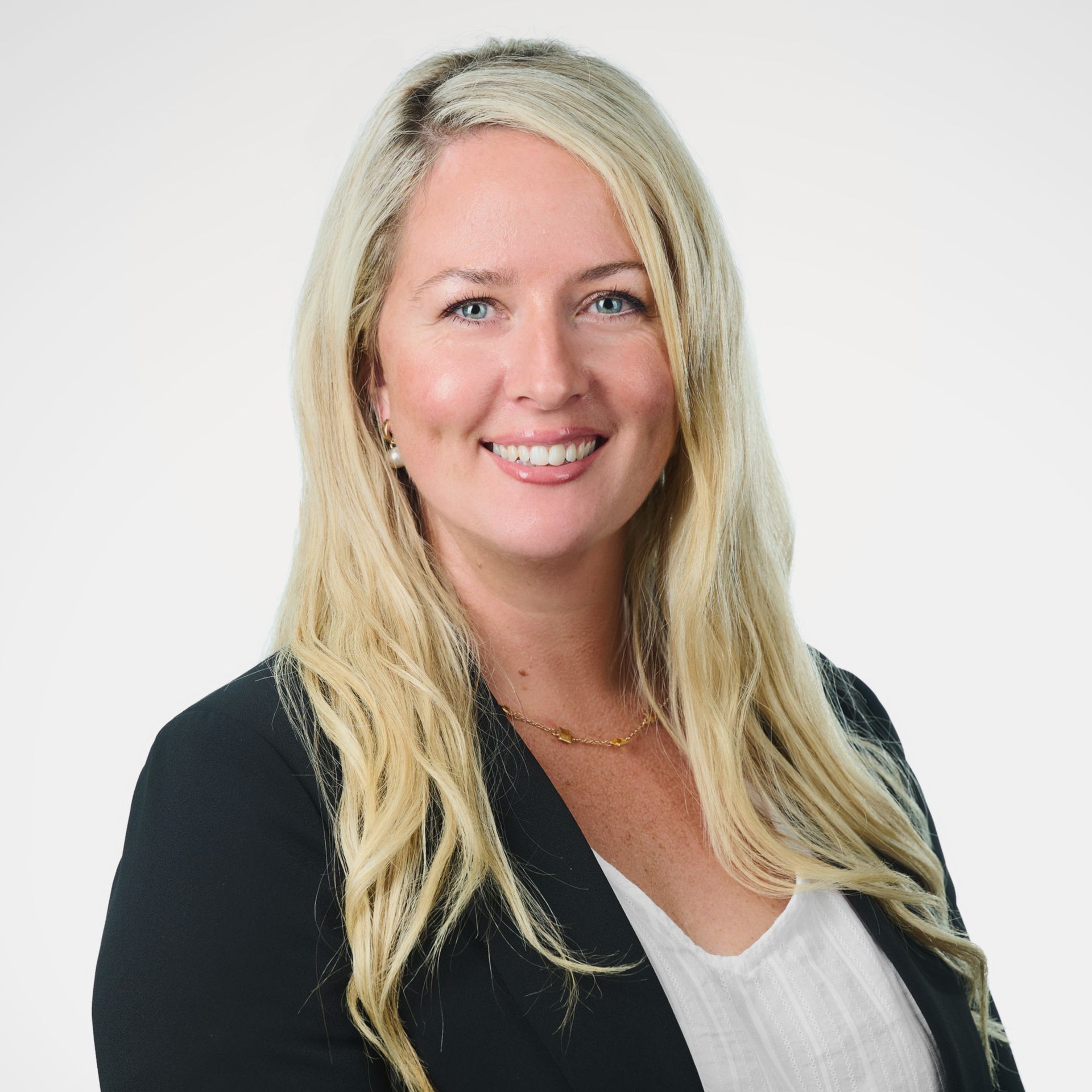  a smiling woman with long blonde hair, wearing a black blazer and white top  best travel agents in New Zealand